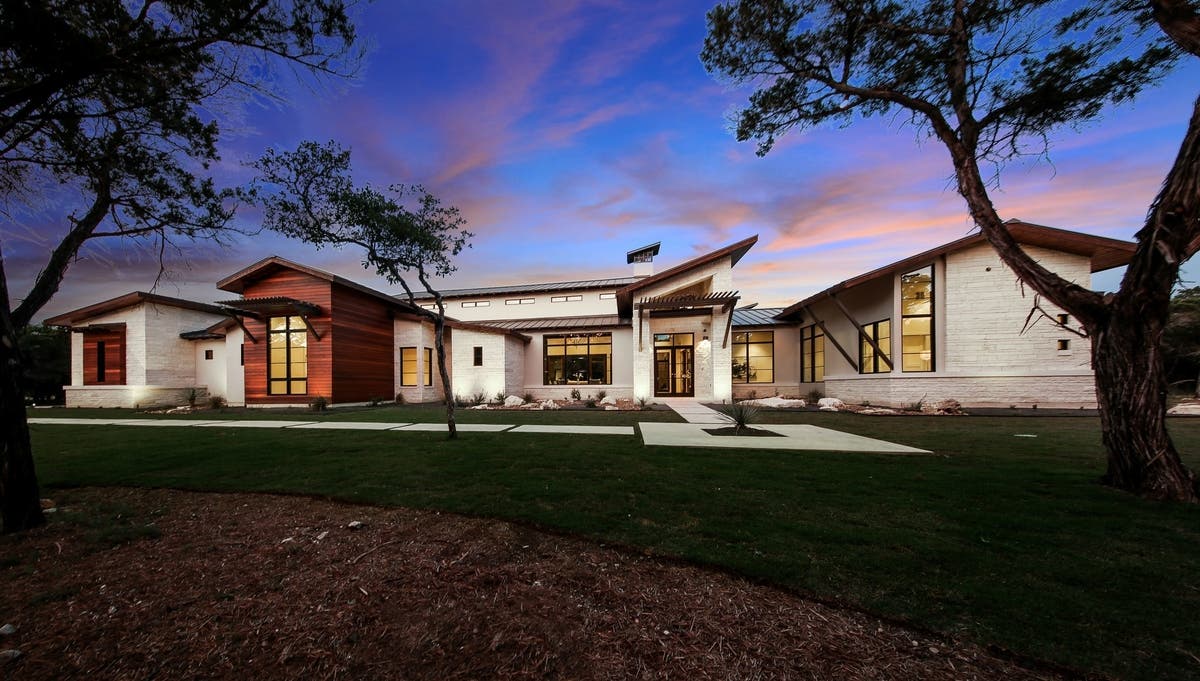Contemporary Hill Country stone and timber residence beneath a twilight sky