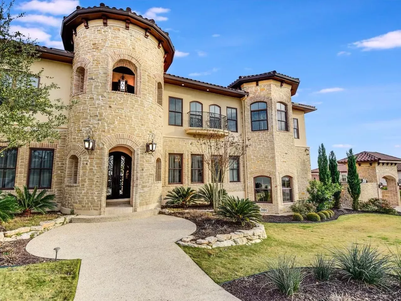 Mediterranean stone residence with turrets, arched windows and landscaped grounds